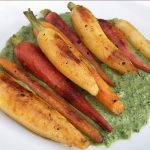 Grilled carrots on a bed of Creamy carrot top pesto